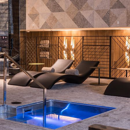 巴塞罗那索菲亚酒店-凯悦无限精选 外观 照片 The photo shows a modern spa or relaxation area. In the foreground, there is a small rectangular pool of water with a sleek metal railing. Surrounding the pool are comfortable lounge chairs, designed for relaxation, likely positioned for users to unw