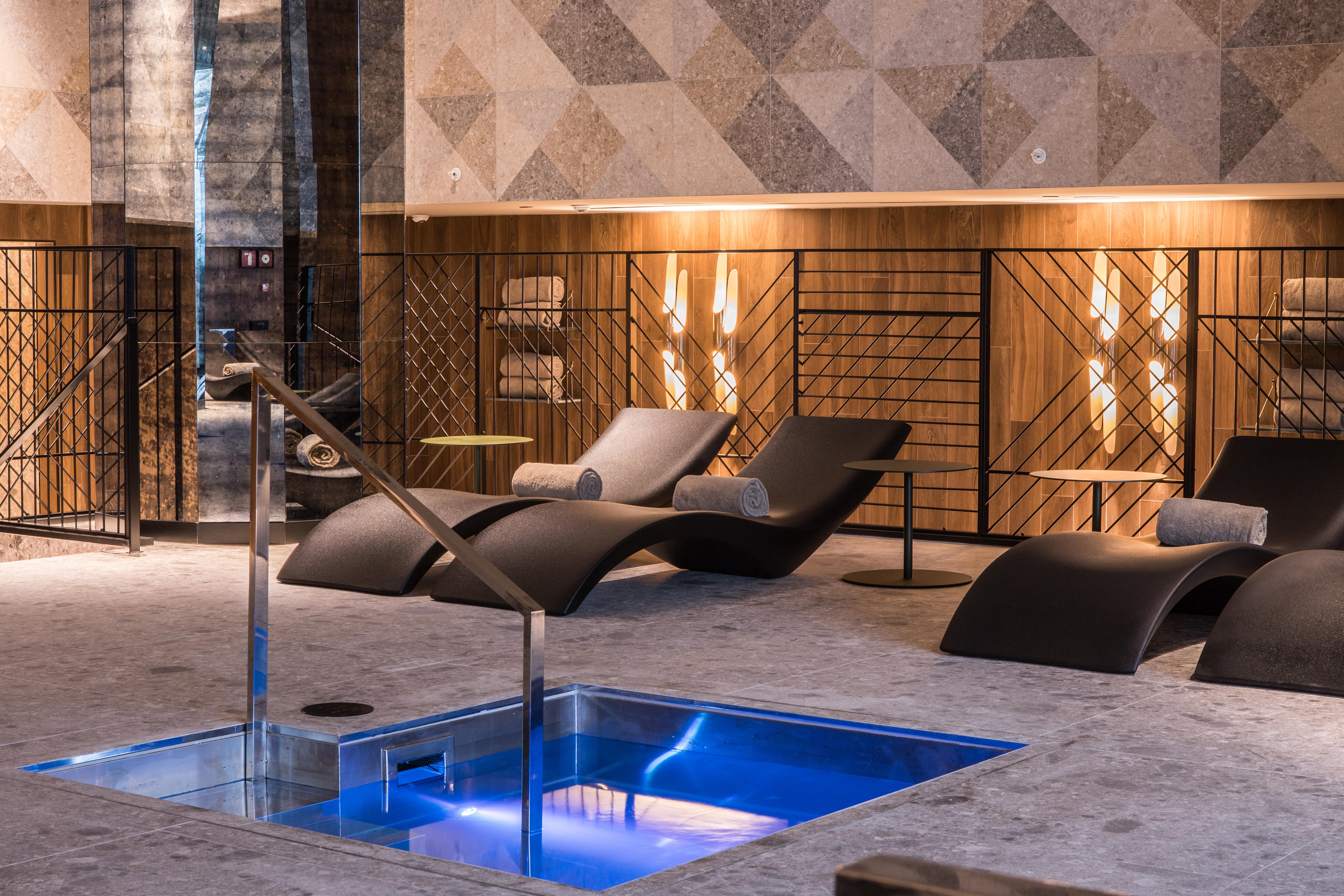 巴塞罗那索菲亚酒店-凯悦无限精选 外观 照片 The photo shows a modern spa or relaxation area. In the foreground, there is a small rectangular pool of water with a sleek metal railing. Surrounding the pool are comfortable lounge chairs, designed for relaxation, likely positioned for users to unw